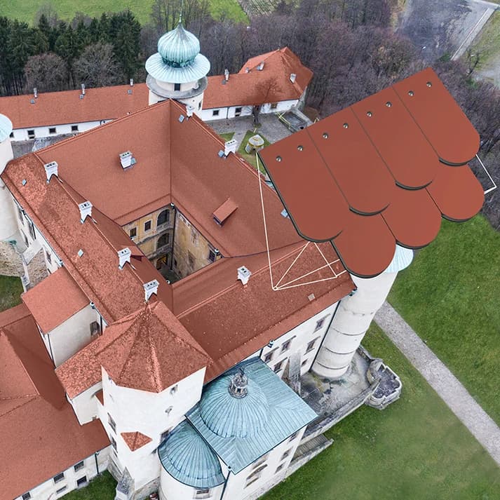 Widok z lotu ptaka na zabytkowy zamek, przy którym zaprezentowano nowoczesny dach z fotowoltaiki jako przykład możliwej integracji technologii z historyczną architekturą