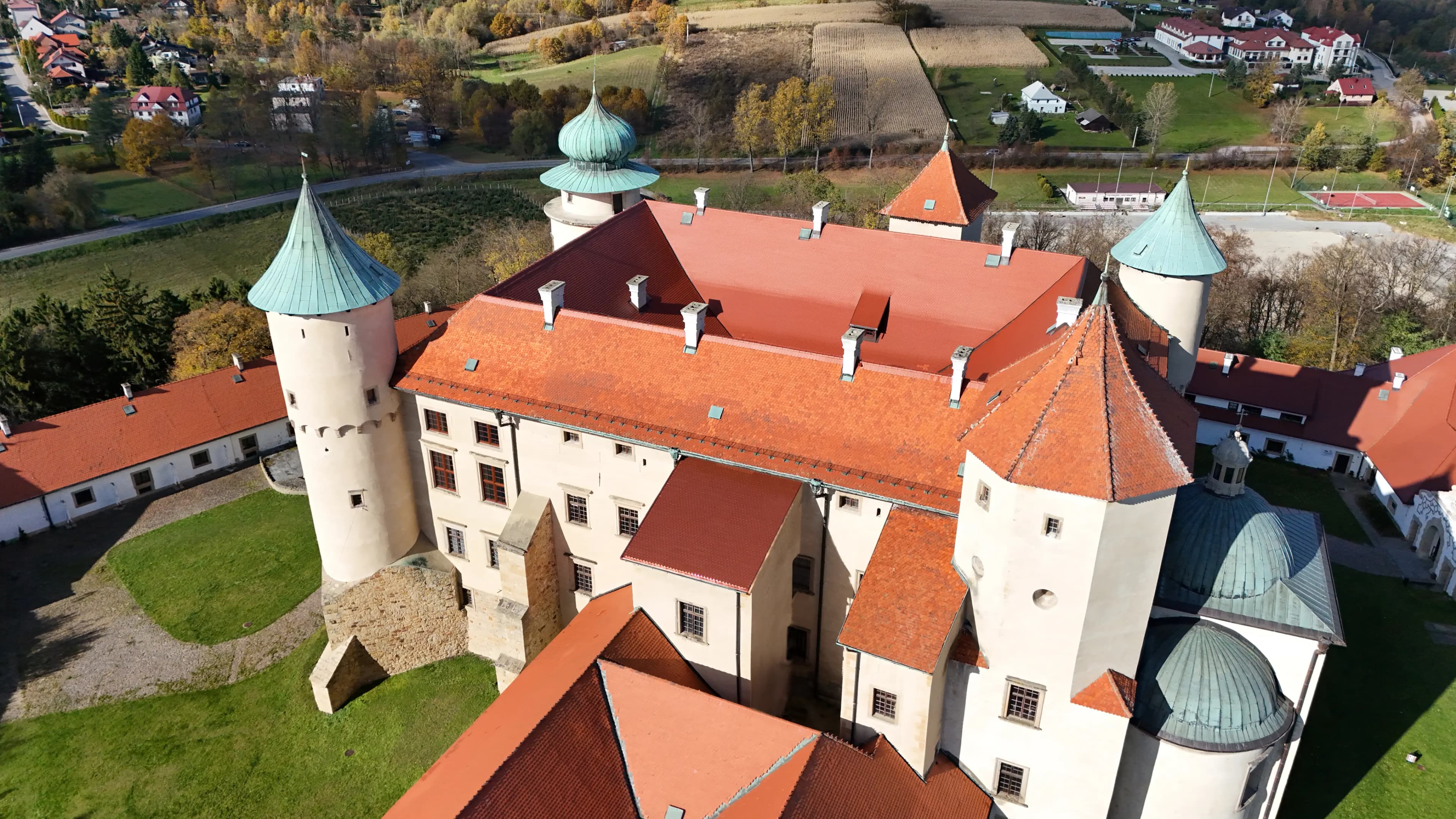 Aerial close-up of Wiśnicz Castle highlighting its red-tiled roofs