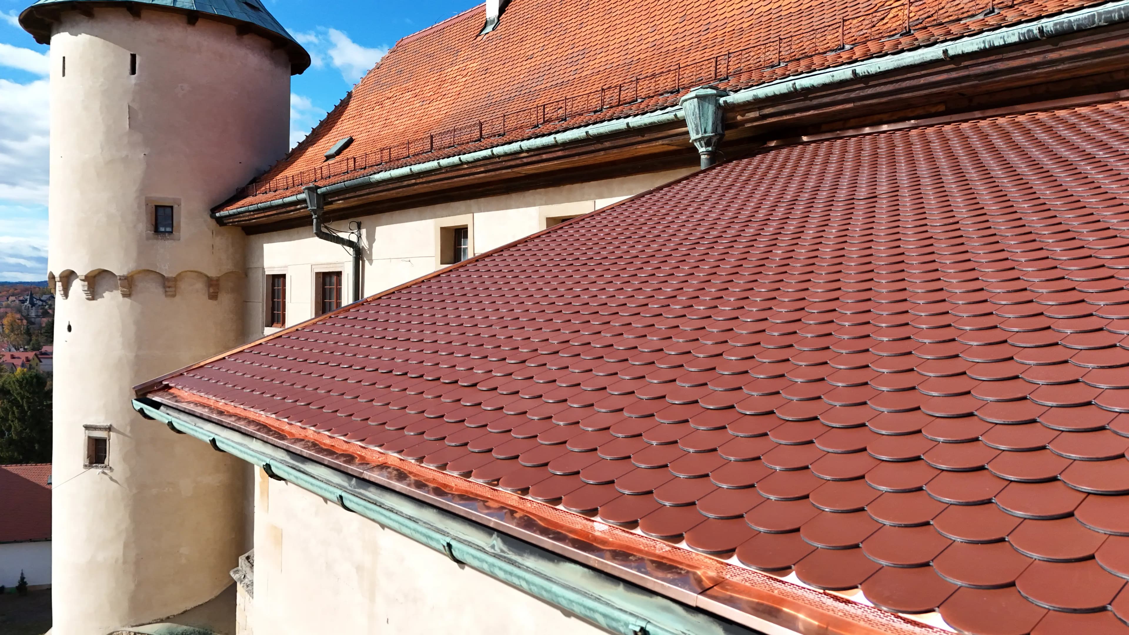 Close-up view of Wiśnicz Castle’s restored roof showing rows of red fish-scale clay tiles